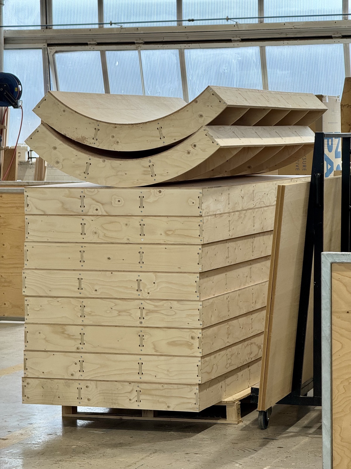 CNC-cut curved plywood walls and modular boxes for a pop-up retail space