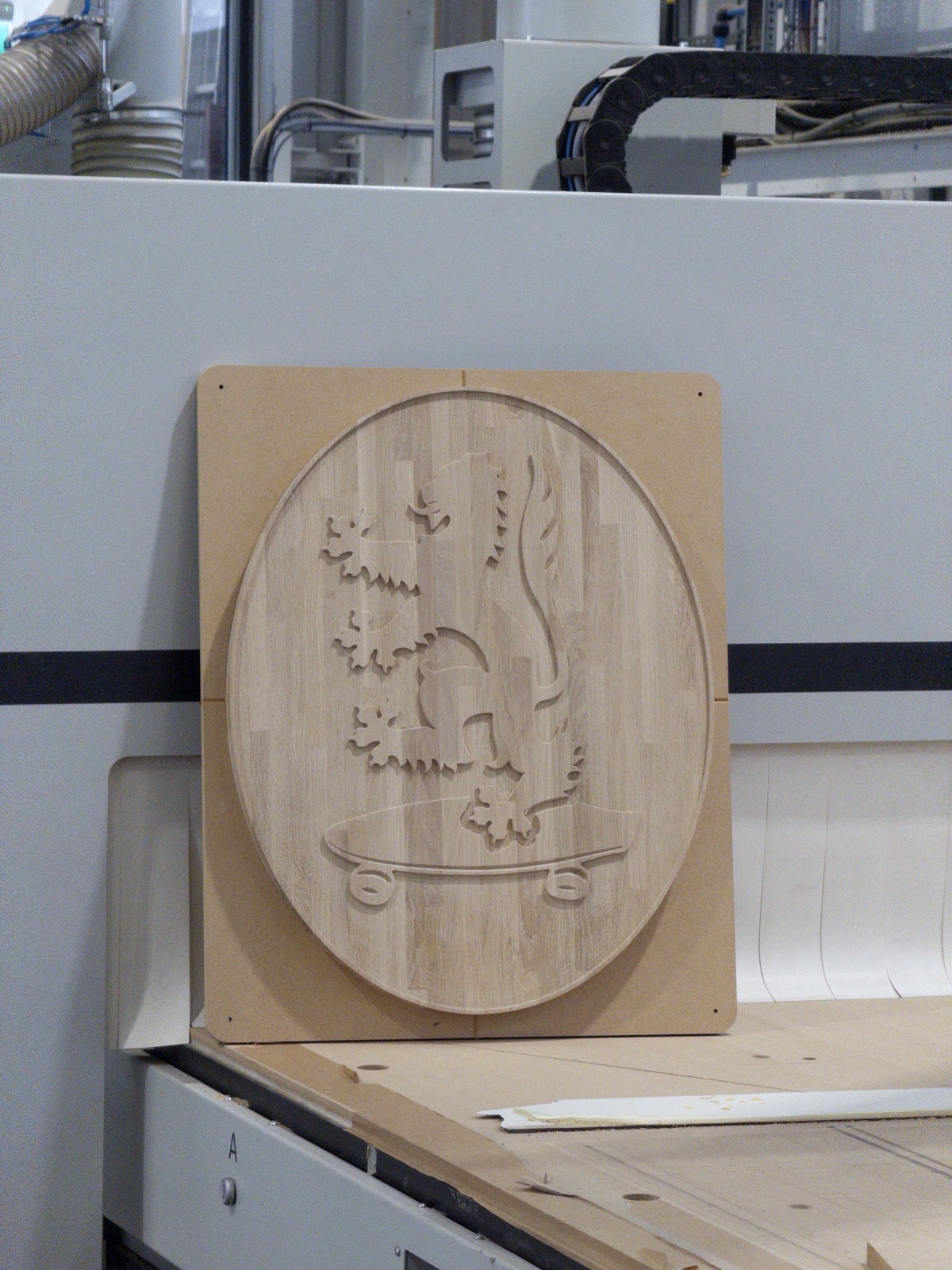 3D relief crest machined into timber on the CNC